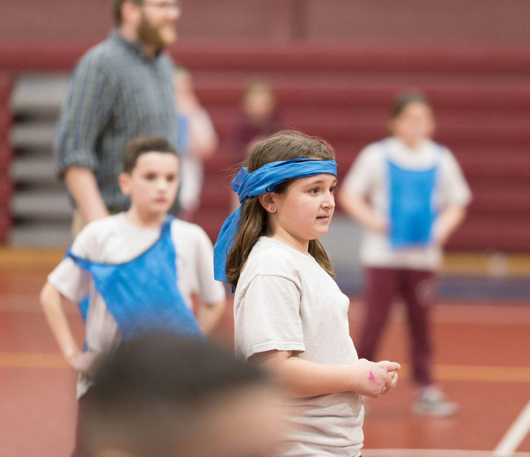 Young female student participating in an after school game in the gym