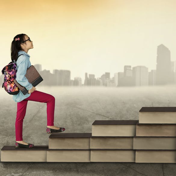  Girl climbing up stairs made of books 