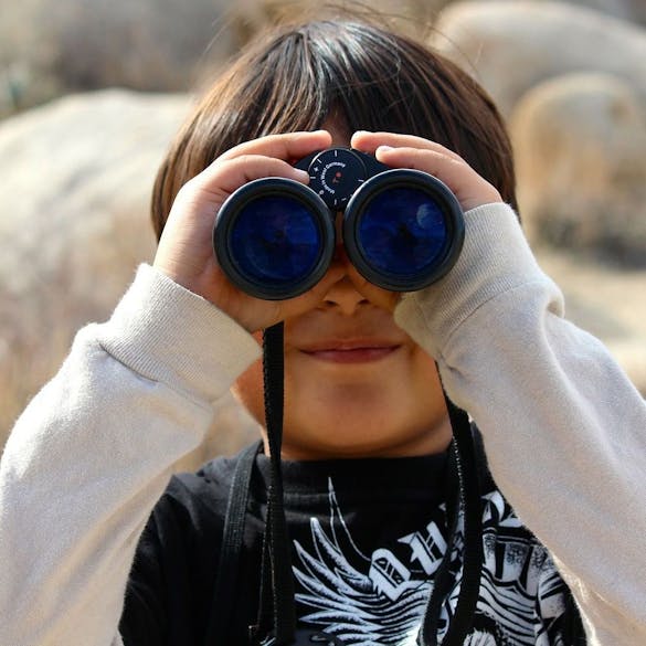  child looking through binoculars 