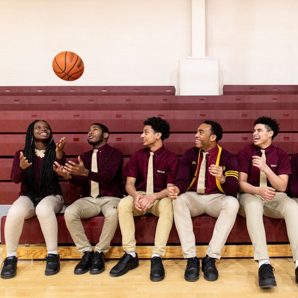  Five teenage students laughing in gym with basketball 