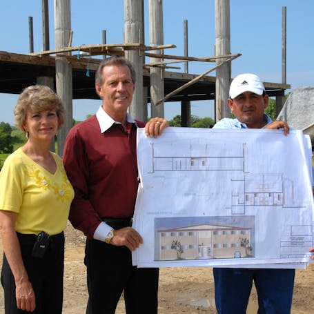  Young Living Foundation - Our Story - Gary and Mary Young holding blueprints of the Young Living Academy 